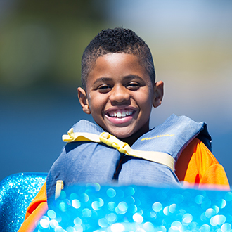 kid with a pfd looking into the camera.
