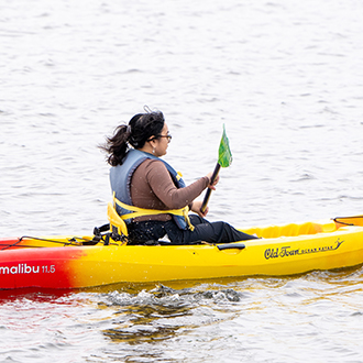 A womaan in a kayak on shoreline lake
