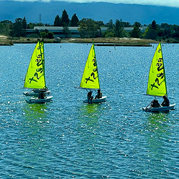 A group of boats on shoreline lake.