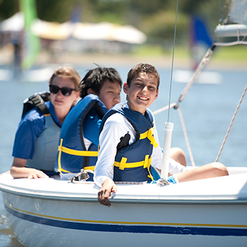 A group of kids in a sailboat