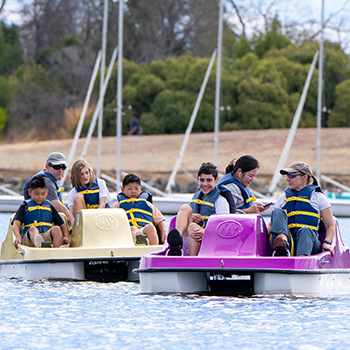 Two groups odf people in paddles obats enjoying themselves