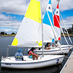 A group of new sailors in a boat sailing on Shoreline Lake.