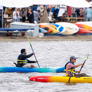 Two ocean kayaks being used on shoreline lake